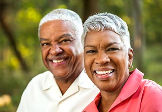Smiling African-American couple in casual clothing enjoying an outdoor walk